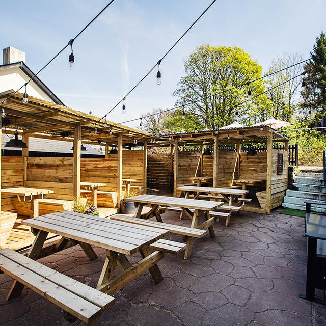 The covered outdoor booths and picnic benches in the pub courtyard